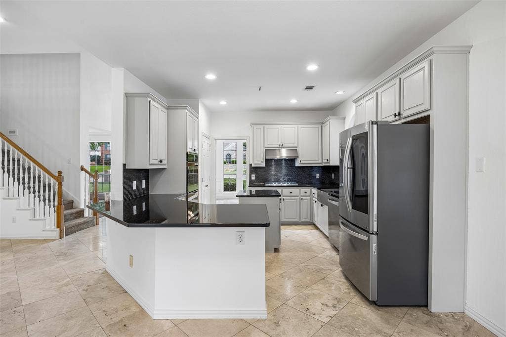 2701 Oates Drive, Plano, TX 75093 Kitchen featuring light gray cabinetry, black countertops, and a dark tile backsplash