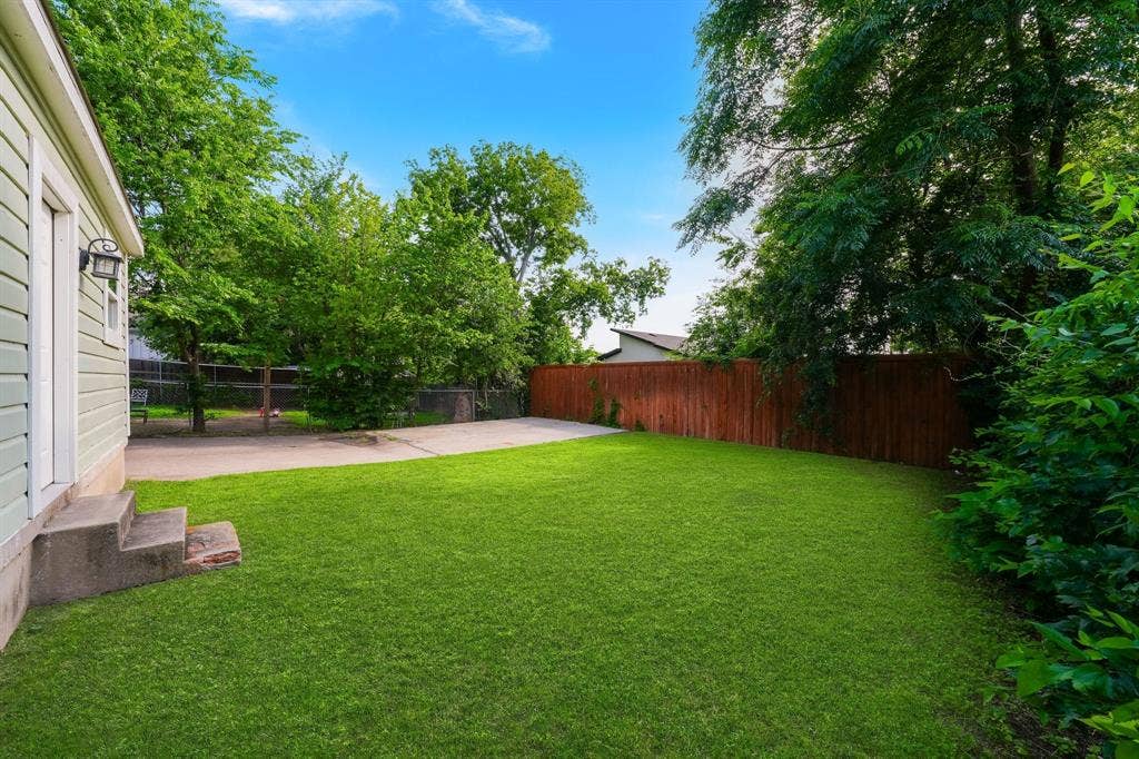 414 Avenue I, Dallas, TX 75203 Expansive green lawn with mature trees and a privacy fence