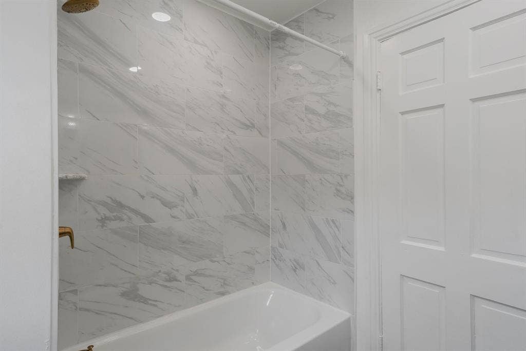 414 Avenue I, Dallas, TX 75203 Bathtub with marble-look tile surround, recessed lighting, and gold rainfall shower head