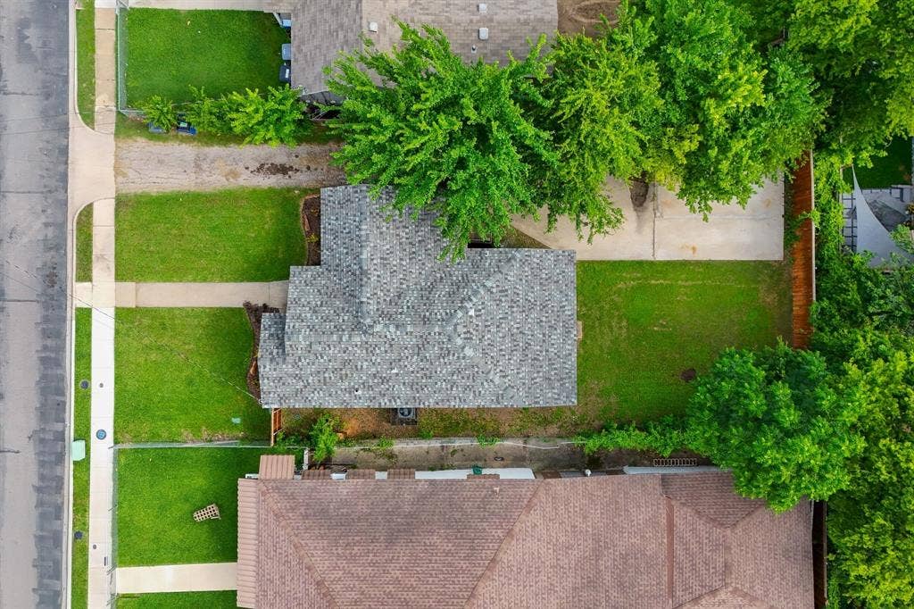 414 Avenue I, Dallas, TX 75203 Aerial perspective showcasing a property with a gray shingle roof, a front lawn, and a concrete driveway