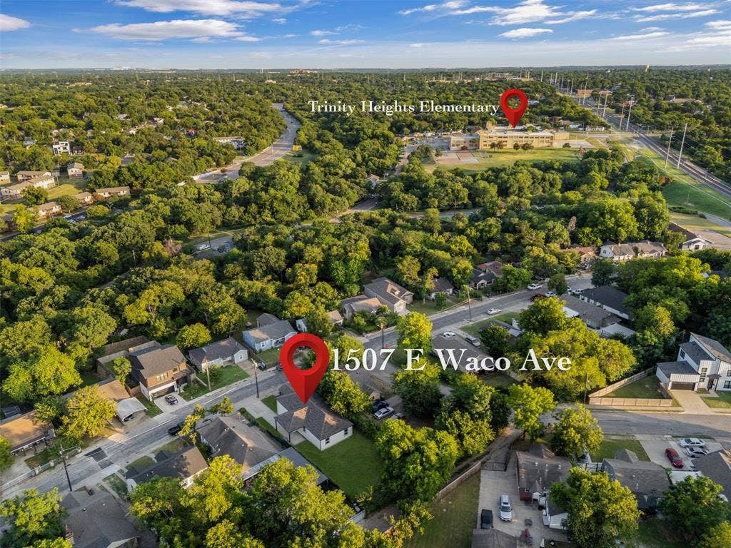 1507 E Waco Avenue, Dallas, TX 75216 Aerial perspective showcasing a residential street with properties featuring green lawns and mature trees