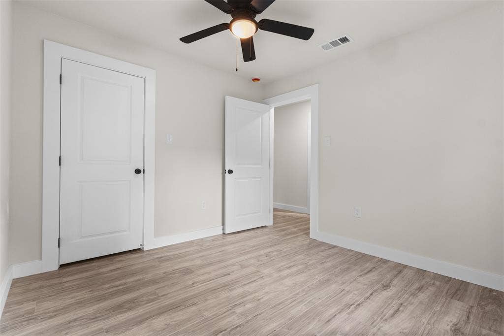 1507 E Waco Avenue, Dallas, TX 75216 Interior room featuring wood-finish flooring, light neutral wall paint, white trim, and a ceiling fan with integrated lighting