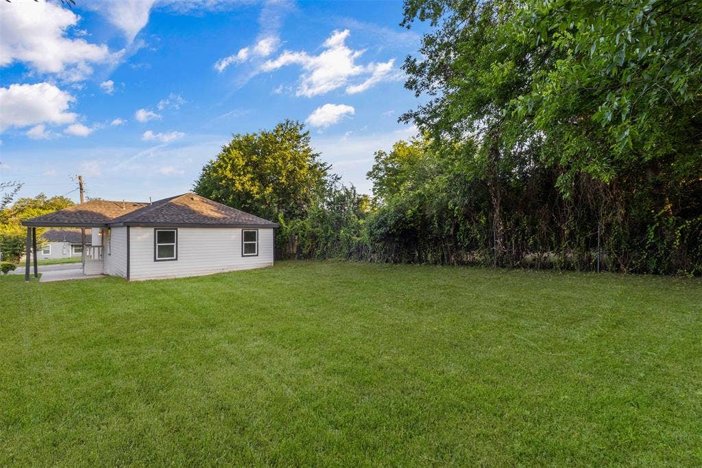 1507 E Waco Avenue, Dallas, TX 75216 Expansive rear yard featuring a large grass area and mature perimeter foliage