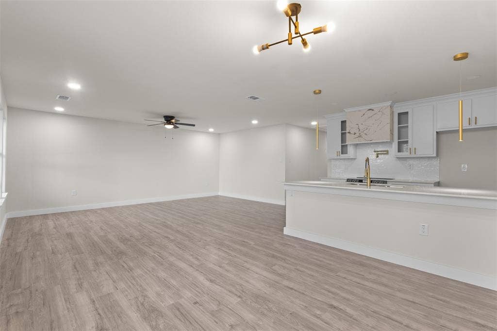 1507 E Waco Avenue, Dallas, TX 75216 Expansive open-concept space featuring wood-finish flooring, recessed lighting, and a contemporary ceiling fan