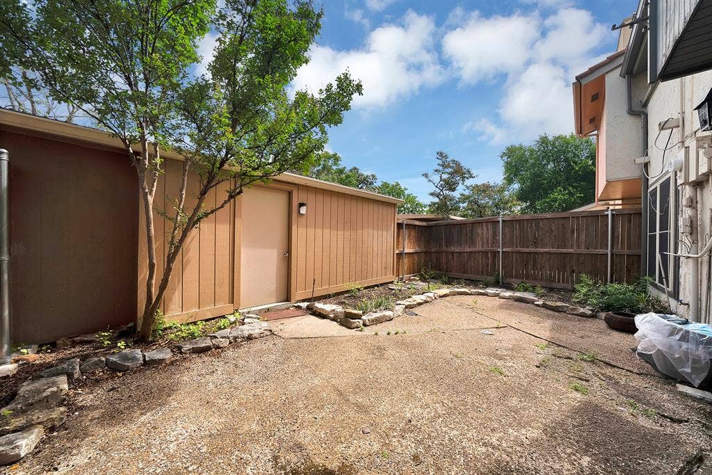 12574 Burninglog Lane, Dallas, TX 75243 Enclosed private yard featuring a wood privacy fence and a detached storage structure