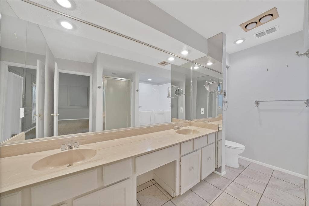 12574 Burninglog Lane, Dallas, TX 75243 Bathroom featuring a double vanity with integrated sinks, a lengthy mirror, recessed lighting, and tile flooring