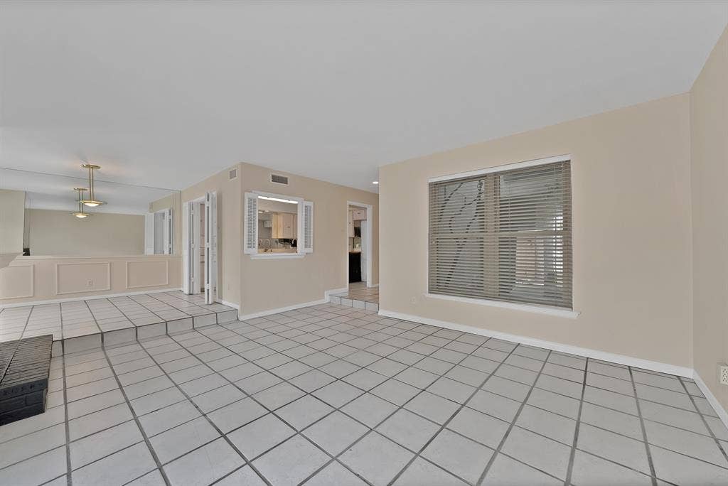 12574 Burninglog Lane, Dallas, TX 75243 Spacious interior featuring light-toned tile flooring throughout and neutral wall paint