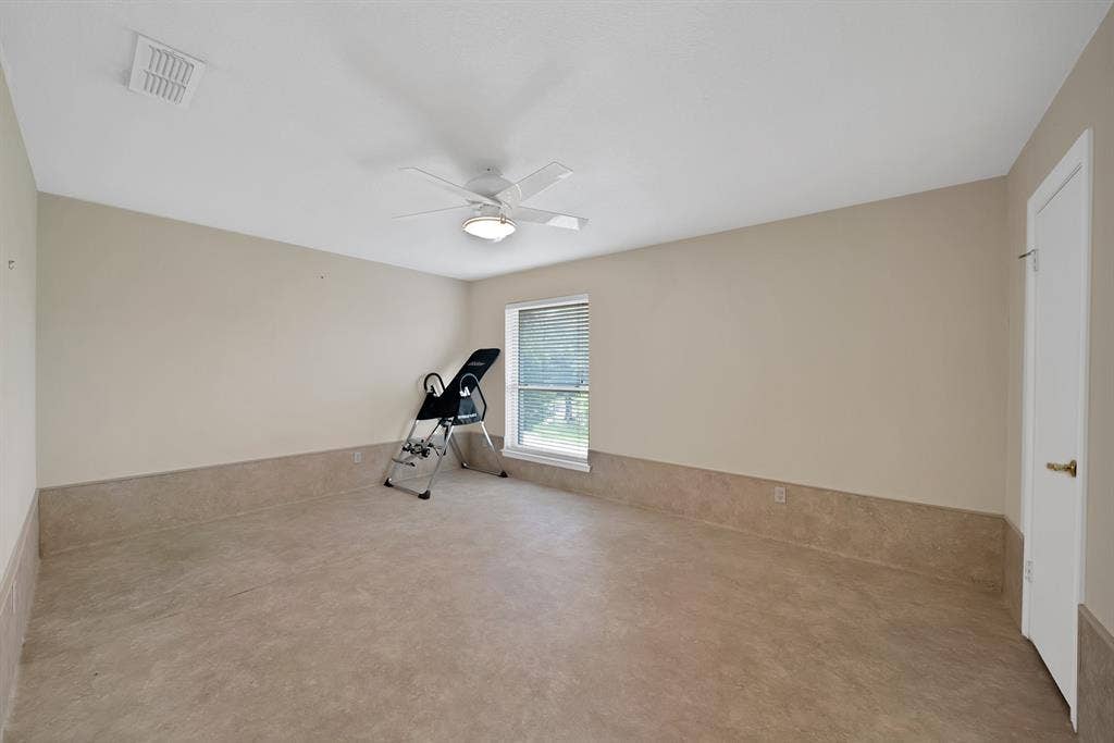 12574 Burninglog Lane, Dallas, TX 75243 Spacious room featuring neutral-toned walls, a ceiling fan with integrated lighting, a window with blinds, and durable flooring