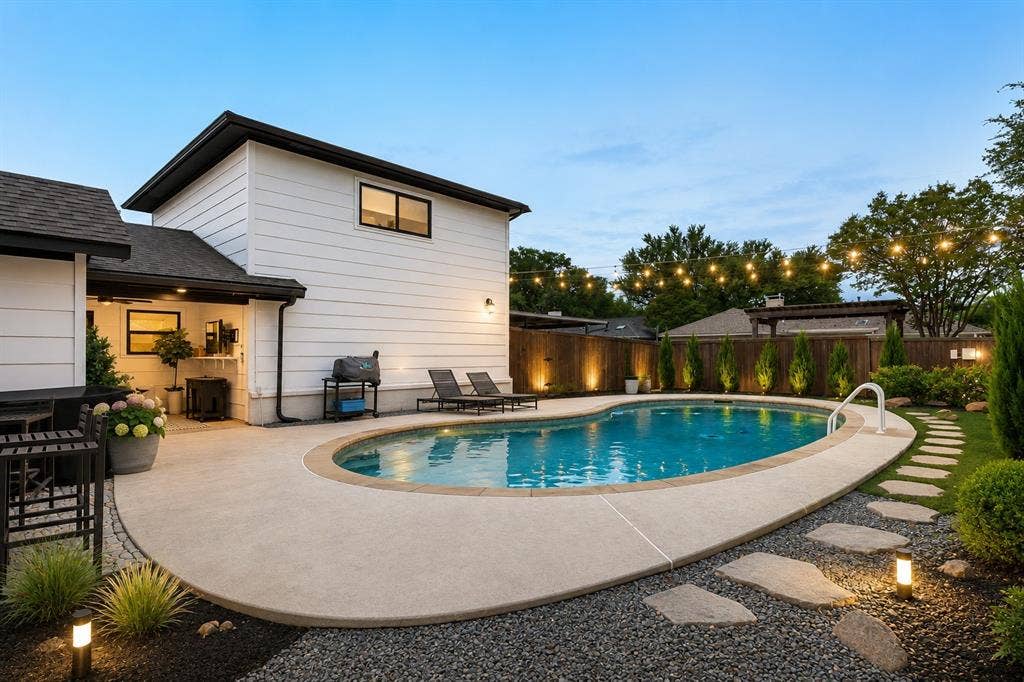 Inviting backyard featuring an in-ground swimming pool with surrounding concrete decking