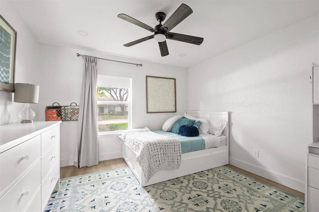Bright room featuring wood-finish flooring and a ceiling fan