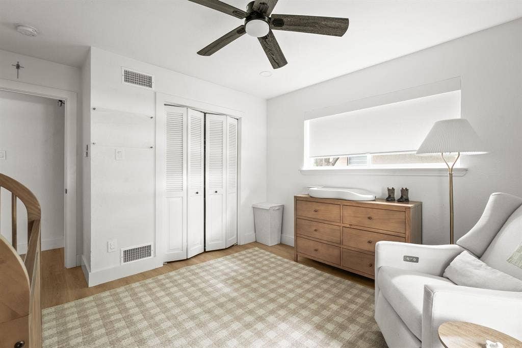 Bright room featuring wood-finish flooring and a ceiling fan with integrated lighting
