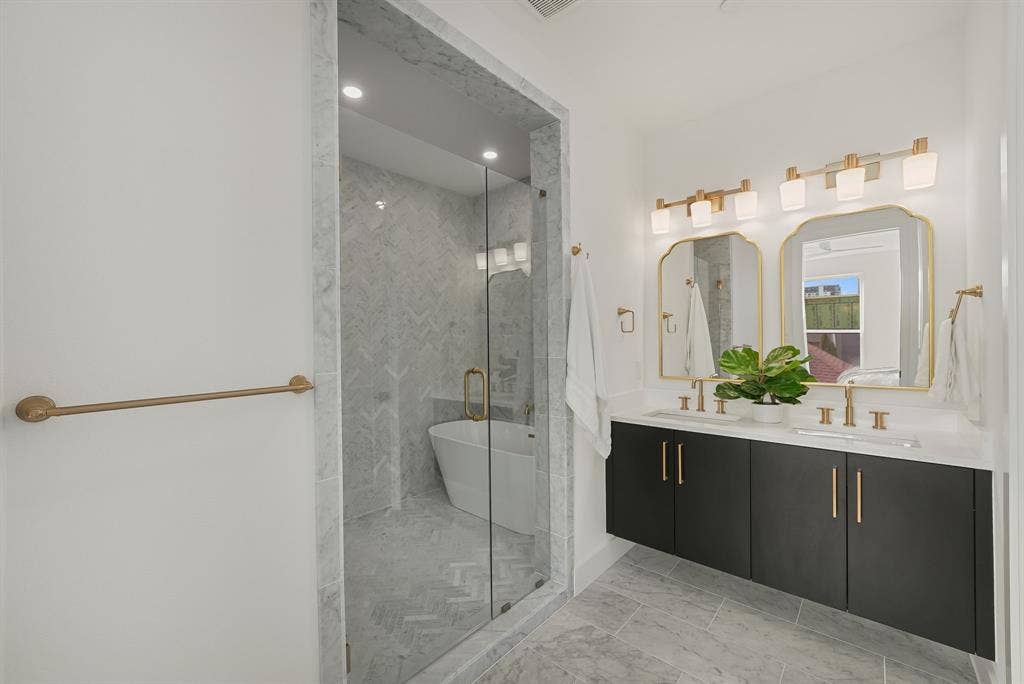 4715 Manett Street, #102, Dallas, TX 75204 Modern bathroom featuring a double vanity with dark cabinetry and gold-tone hardware