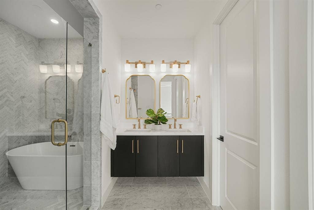 4715 Manett Street, #102, Dallas, TX 75204 Modern bathroom featuring a floating dual-sink vanity with a light countertop and gold-finish fixtures