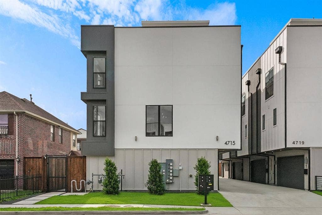 4715 Manett Street, #102, Dallas, TX 75204 Modern multi-story facade featuring a white stucco finish with dark panel accents