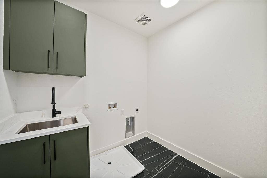 4715 Manett Street, #102, Dallas, TX 75204 Dedicated laundry area featuring a utility sink, white countertop, and dark green cabinetry