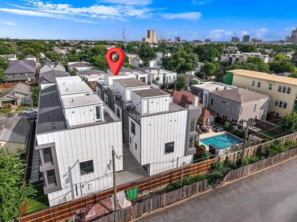 4715 Manett Street, #102, Dallas, TX 75204 Modern multi-story residential building featuring a white and gray facade, multiple balconies, and a private rooftop terrace
