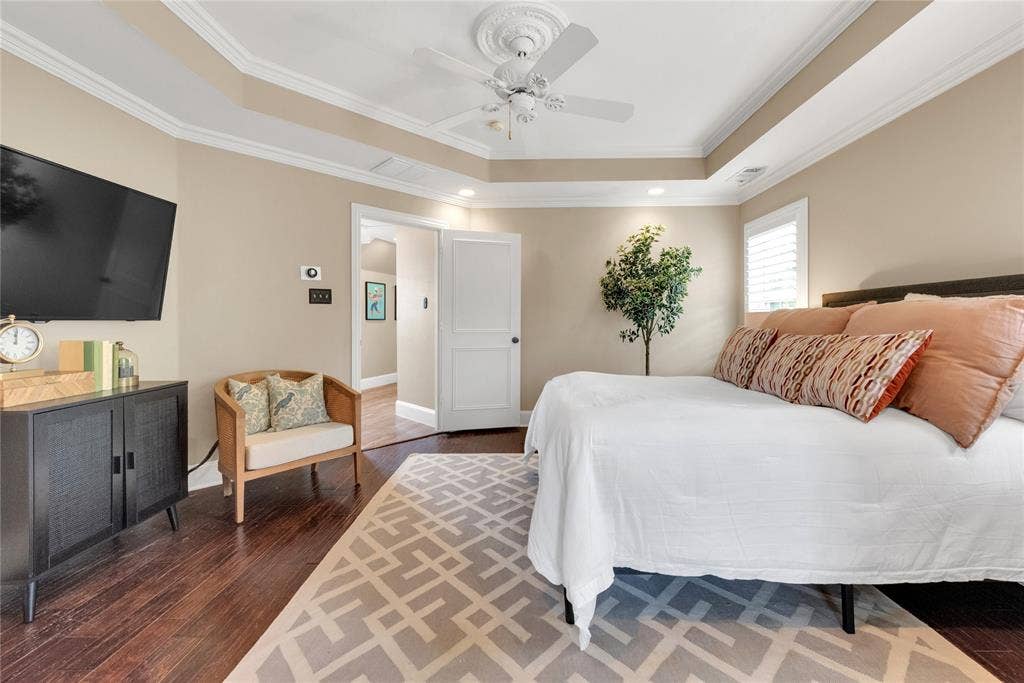 5102 Ridgedale Avenue, Dallas, TX 75206 Tray ceiling with crown molding, ceiling fan, dark wood-finish flooring, plantation shutters, and recessed lighting