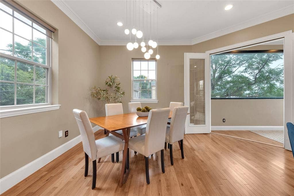 5102 Ridgedale Avenue, Dallas, TX 75206 Dining area featuring hardwood flooring, crown molding, a contemporary chandelier, multiple windows, and glass-paneled French doors