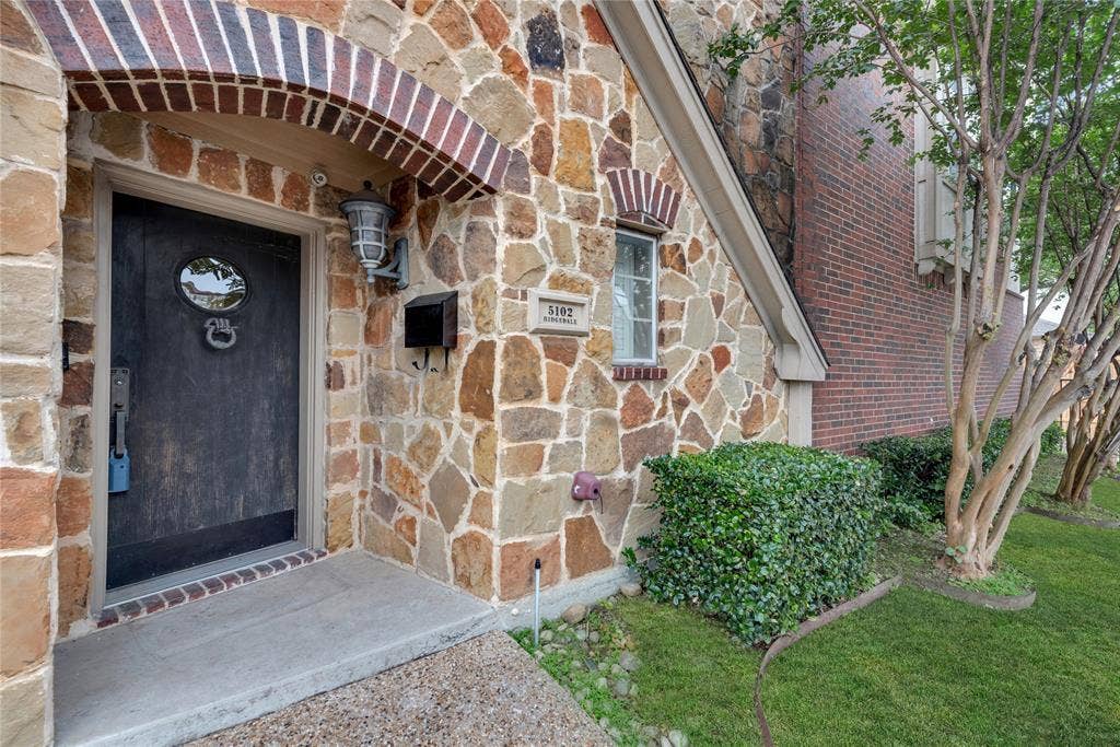 5102 Ridgedale Avenue, Dallas, TX 75206 Stone façade entryway featuring a dark wood-finish door with an oval window and decorative knocker