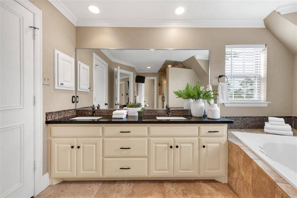 5102 Ridgedale Avenue, Dallas, TX 75206 Bathroom vanity featuring dual under-mount sinks, a black countertop, and a large wall-mounted mirror