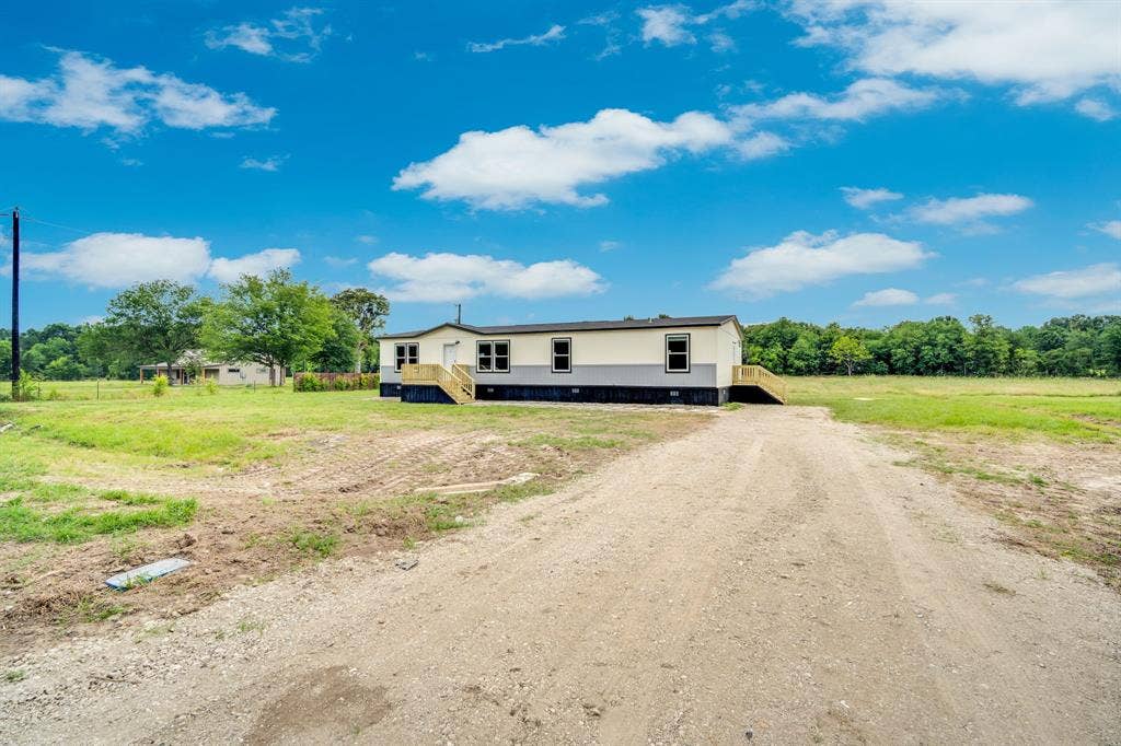 14820 Hyde-A-Way Lane, Mabank, TX 75147 Single-story residence featuring light-colored siding with dark trim accents