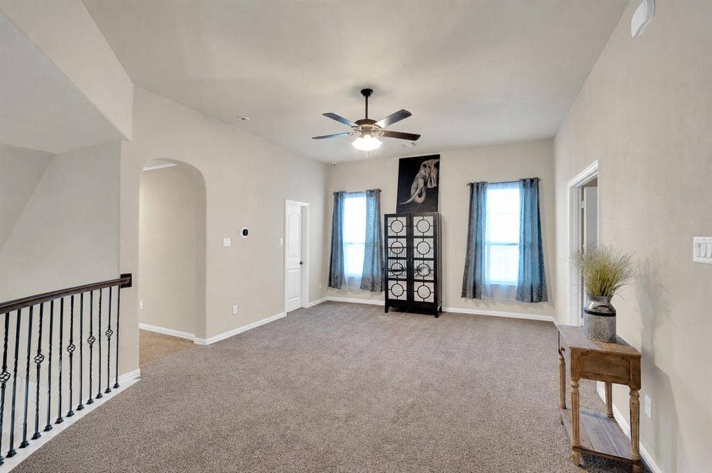 Another view of the upstairs game room featuring natural light.