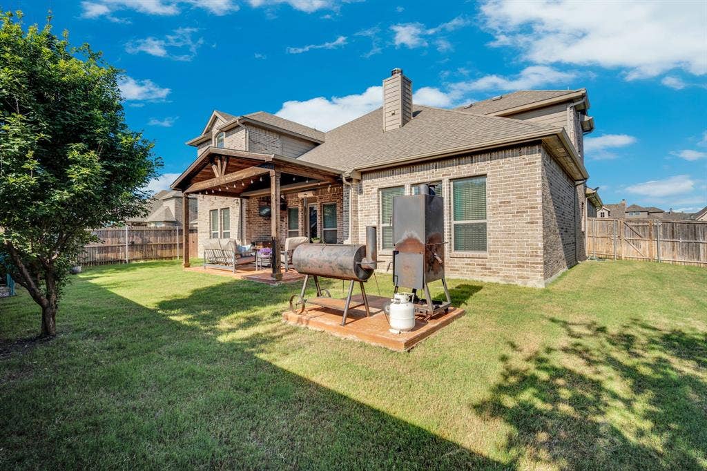View of the back of the home featuring the large covered patio and grilling area.