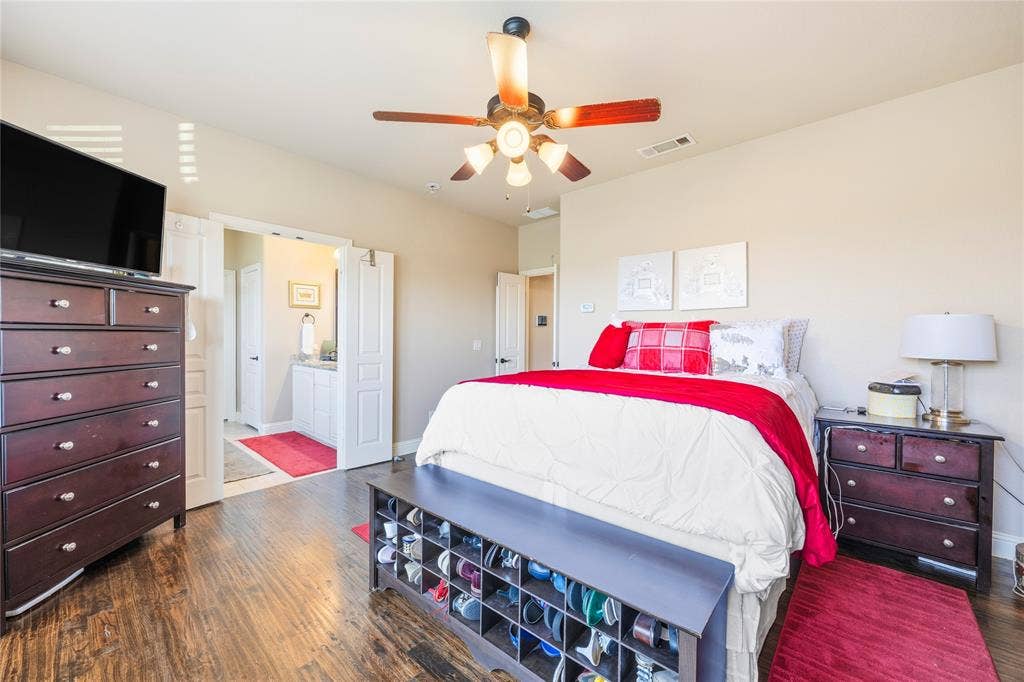 1133 Vickery Drive, DeSoto, TX 75115 1st floor Primary Bedroom one featuring a multi-pane window, wood-finish flooring, and a ceiling fan with integrated lighting