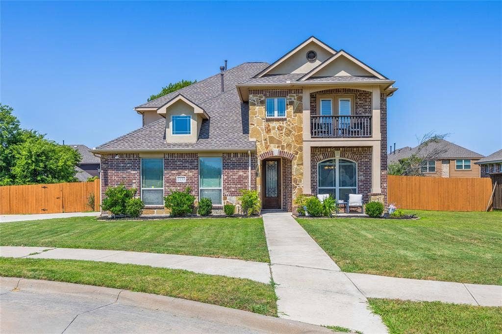 1133 Vickery Drive, DeSoto, TX 75115 Two-story, double primary residence featuring a brick and stone facade, a gabled roofline, and an upper-level balcony.