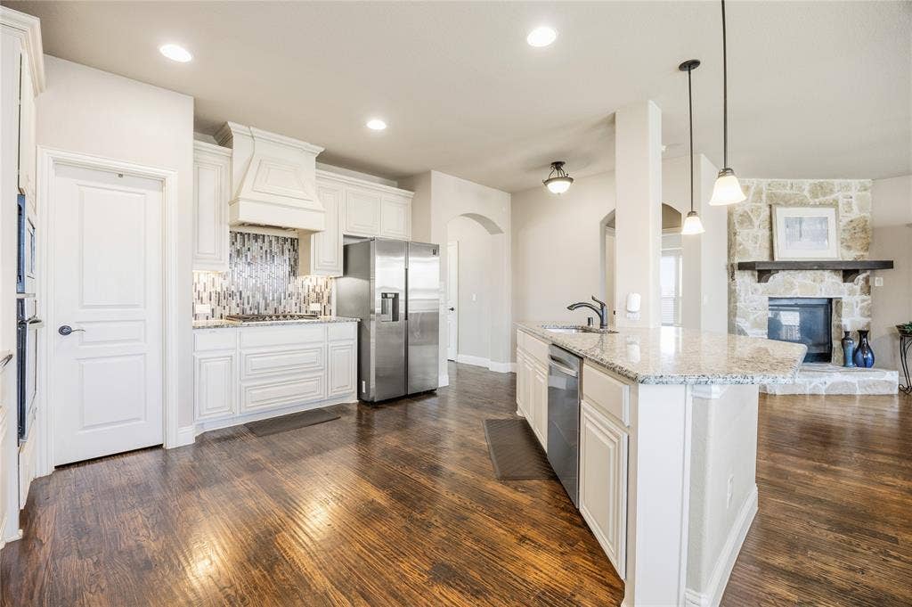 1133 Vickery Drive, DeSoto, TX 75115 Open-concept kitchen featuring white cabinetry, granite countertops, and wood-finish flooring