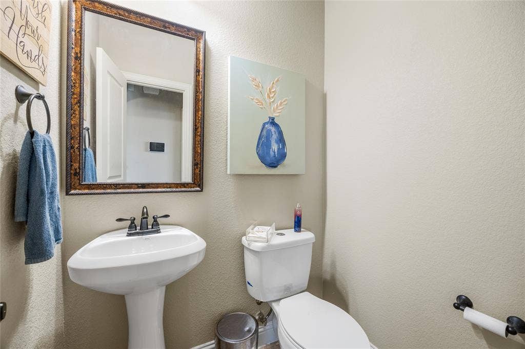 1133 Vickery Drive, DeSoto, TX 75115 Half-bath 1 floor. Pedestal sink with oil-rubbed bronze faucet, framed mirror, and coordinating towel ring