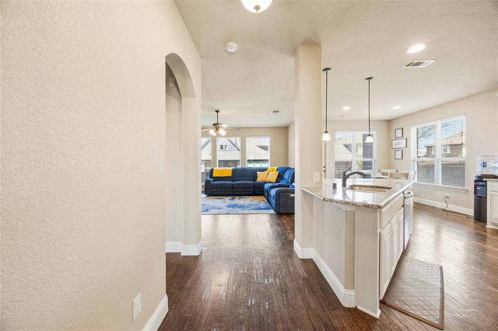 1133 Vickery Drive, DeSoto, TX 75115 Open-concept interior featuring wood-finish flooring, a kitchen island with pendant lighting, recessed lighting, and an arched doorway