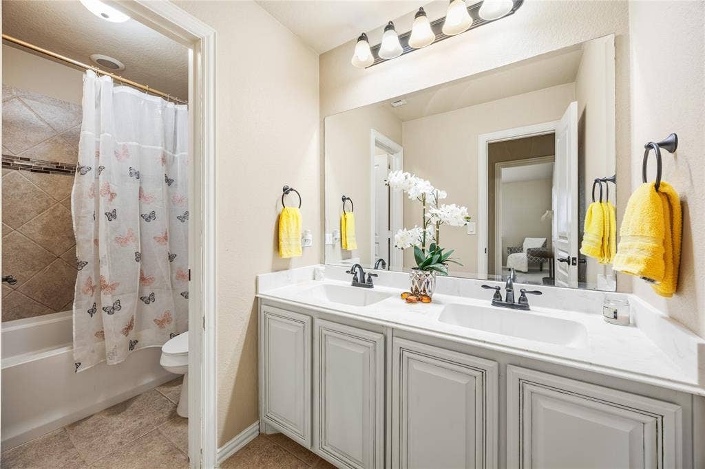 1133 Vickery Drive, DeSoto, TX 75115 2nd floor shared bathroom for bedroom 3, 4, and 5. Dual sink vanity with white countertop and shower, tub combo.