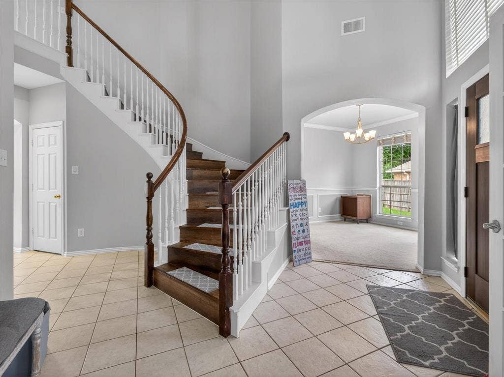 1712 Tealwood Lane, Corinth, TX 76210 Grand entryway featuring a curved staircase with wood-finish treads and white balusters