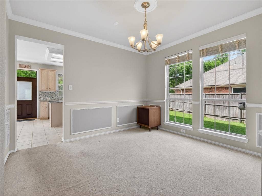 1712 Tealwood Lane, Corinth, TX 76210 Carpeted living space featuring two large windows with horizontal blinds and a decorative chandelier