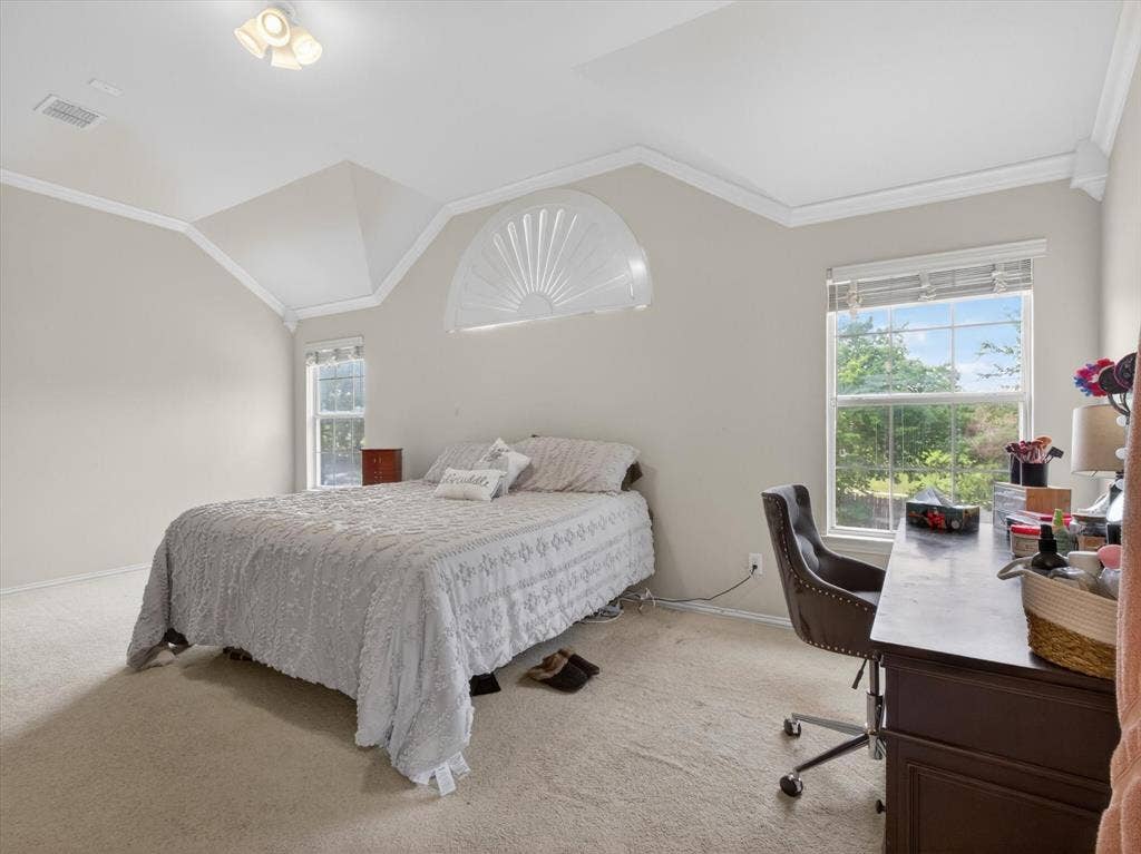 1712 Tealwood Lane, Corinth, TX 76210 Spacious room featuring vaulted ceilings, crown molding, two large windows, a decorative arched transom, and neutral carpeting