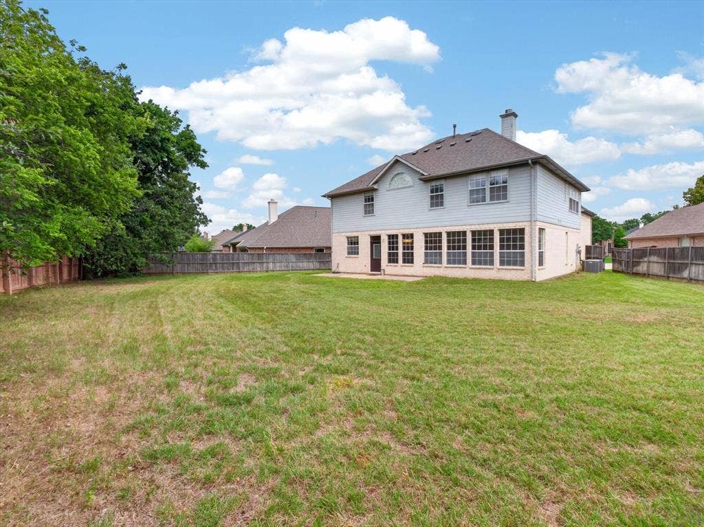 1712 Tealwood Lane, Corinth, TX 76210 Expansive backyard featuring a manicured lawn, established perimeter fencing, and mature trees
