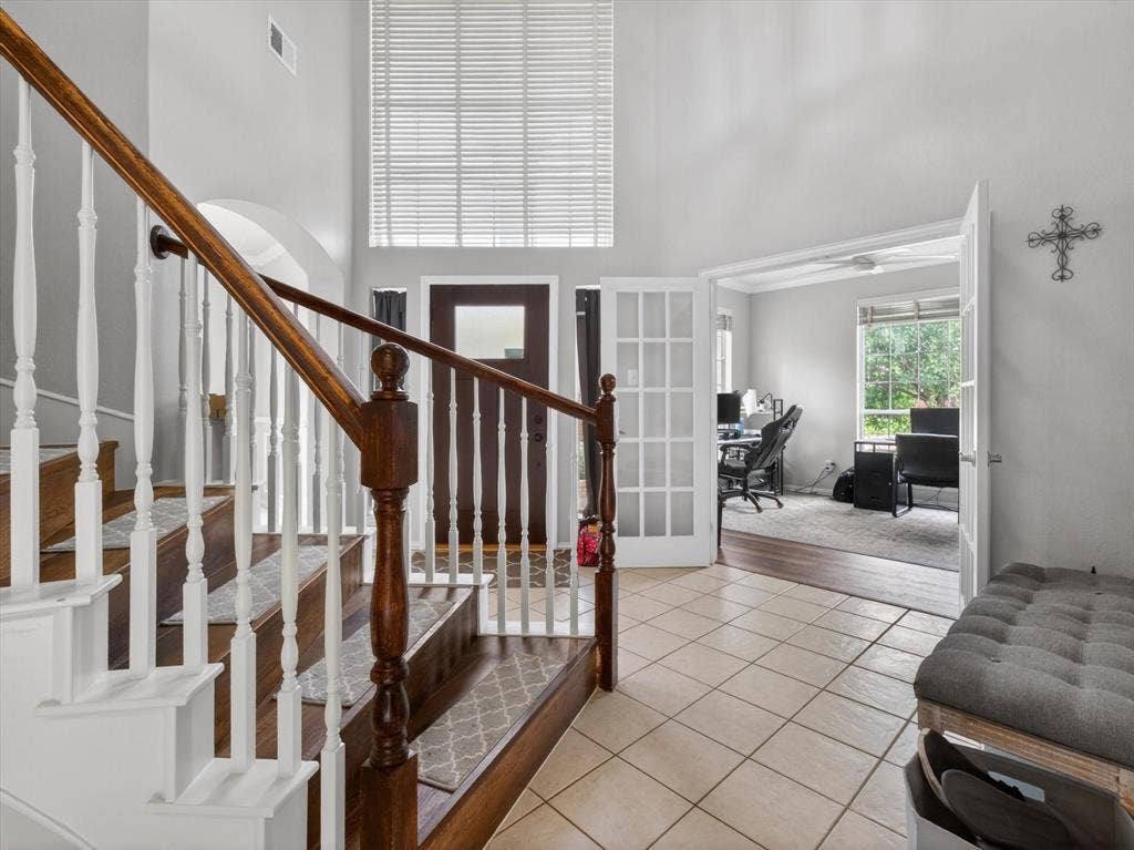 1712 Tealwood Lane, Corinth, TX 76210 Entryway featuring a grand staircase with wood treads and white risers, wood-finish flooring, and tile flooring