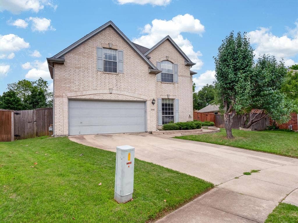 1712 Tealwood Lane, Corinth, TX 76210 Brick exterior two-story residence featuring a two-car garage, established front yard landscaping, and a concrete driveway