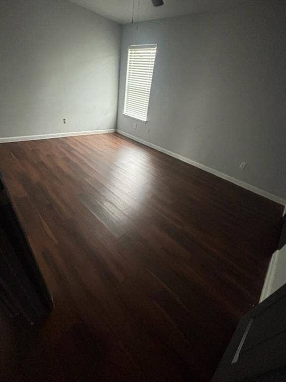 1902 Angelina Drive, Dallas, TX 75212 Spacious room featuring rich wood-finish flooring, light gray wall paint, and a single window with horizontal blinds