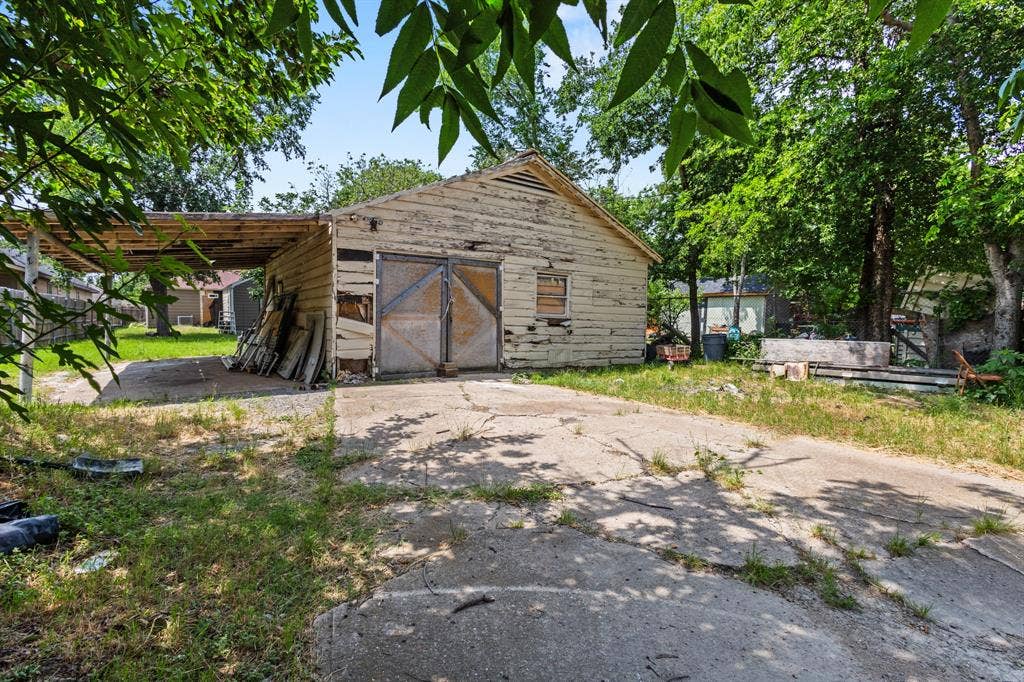 2006 Fort Worth Street, Grand Prairie, TX 75050 Detached storage structure featuring wood siding and dual barn doors