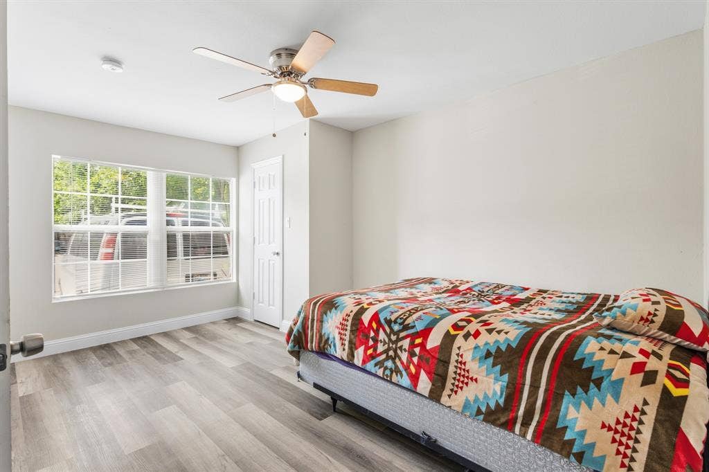 2006 Fort Worth Street, Grand Prairie, TX 75050 Spacious room featuring light gray walls and wood-finish flooring