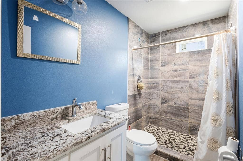 2006 Fort Worth Street, Grand Prairie, TX 75050 Bathroom featuring a white vanity with a granite-style countertop and undermount sink