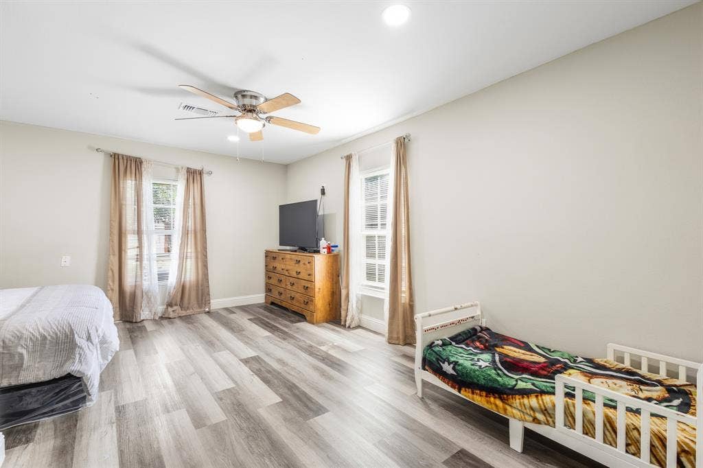 2006 Fort Worth Street, Grand Prairie, TX 75050 Spacious room featuring wood-finish flooring, light-colored walls, and a ceiling fan with integrated lighting