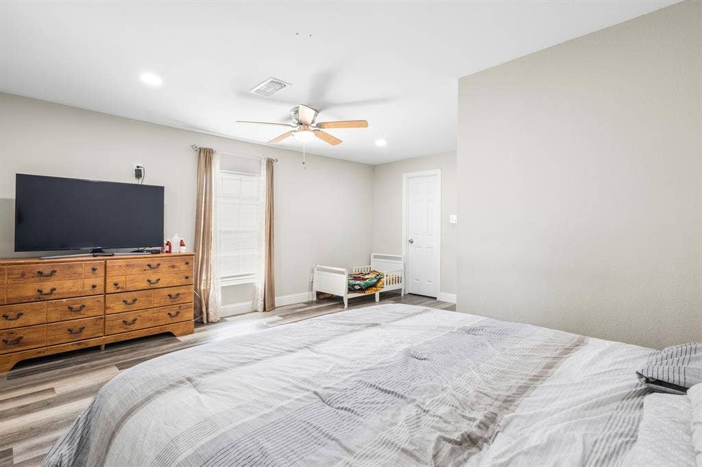 2006 Fort Worth Street, Grand Prairie, TX 75050 Spacious room featuring light-toned walls, wood-finish flooring, a ceiling fan, recessed lighting, and a white interior door