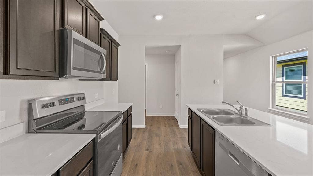 1631 Blaire Drive, Tyler, TX 75702 Kitchen featuring dark wood cabinetry, stainless steel appliances, light countertops, wood-finish flooring, and recessed lighting