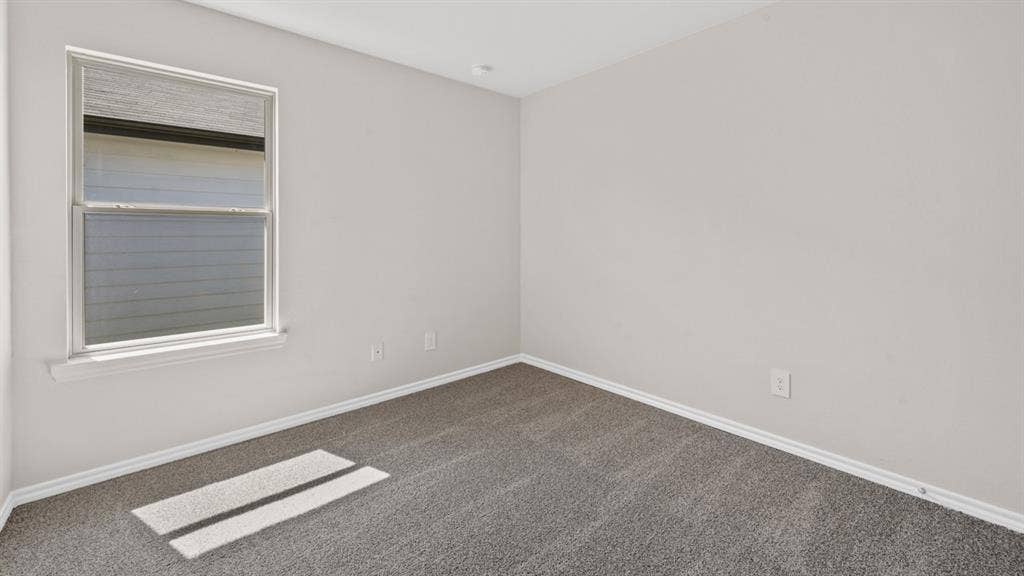 1631 Blaire Drive, Tyler, TX 75702 Bedroom featuring light gray wall paint, gray carpeting, white trim, and a double-pane window