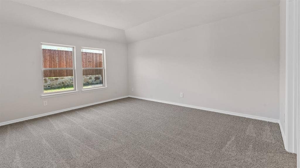 1631 Blaire Drive, Tyler, TX 75702 Spacious room featuring neutral carpeting, light-toned walls, and a vaulted ceiling