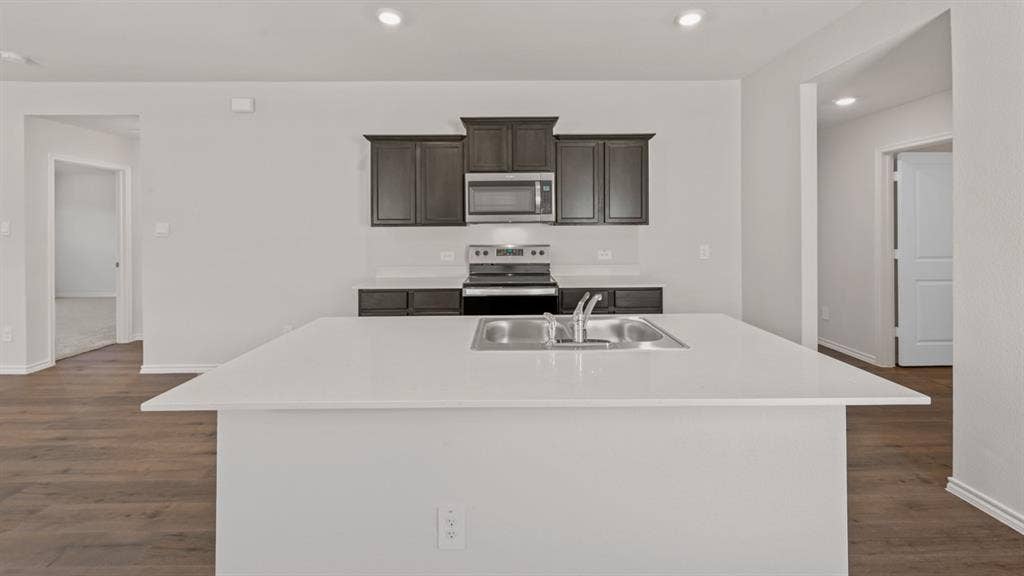 1631 Blaire Drive, Tyler, TX 75702 Kitchen featuring a large central island with an undermount double-basin stainless steel sink and white countertops