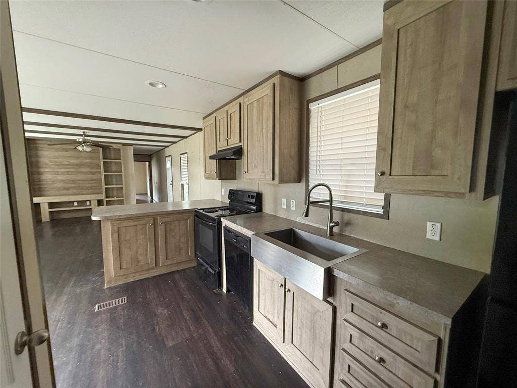 716 Quail Run Court, Seven Points, TX 75143 Kitchen featuring wood-finish cabinetry, stainless steel farmhouse sink, and black appliances